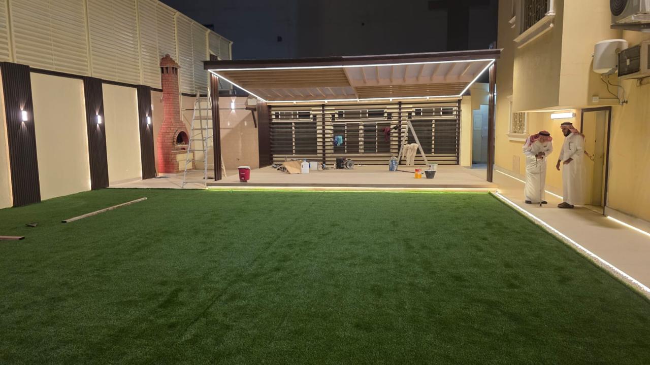 جلسة خارجية مع مظلة وعشب صناعي